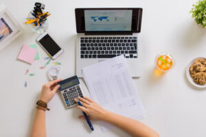 hands with calculator and papers at office table